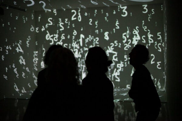 silhouettes of people in front of lighted art exhibit