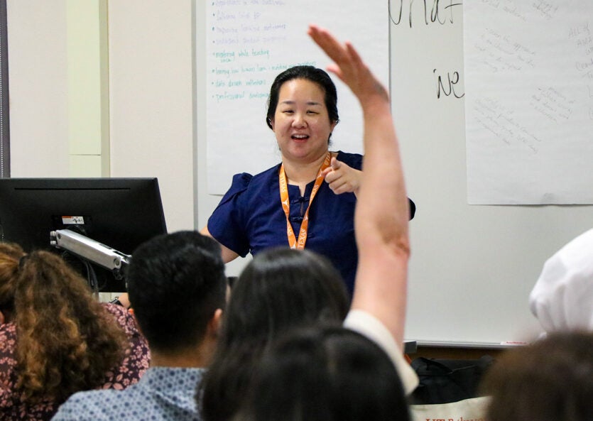 A faculty member answers a question from an audience of peers