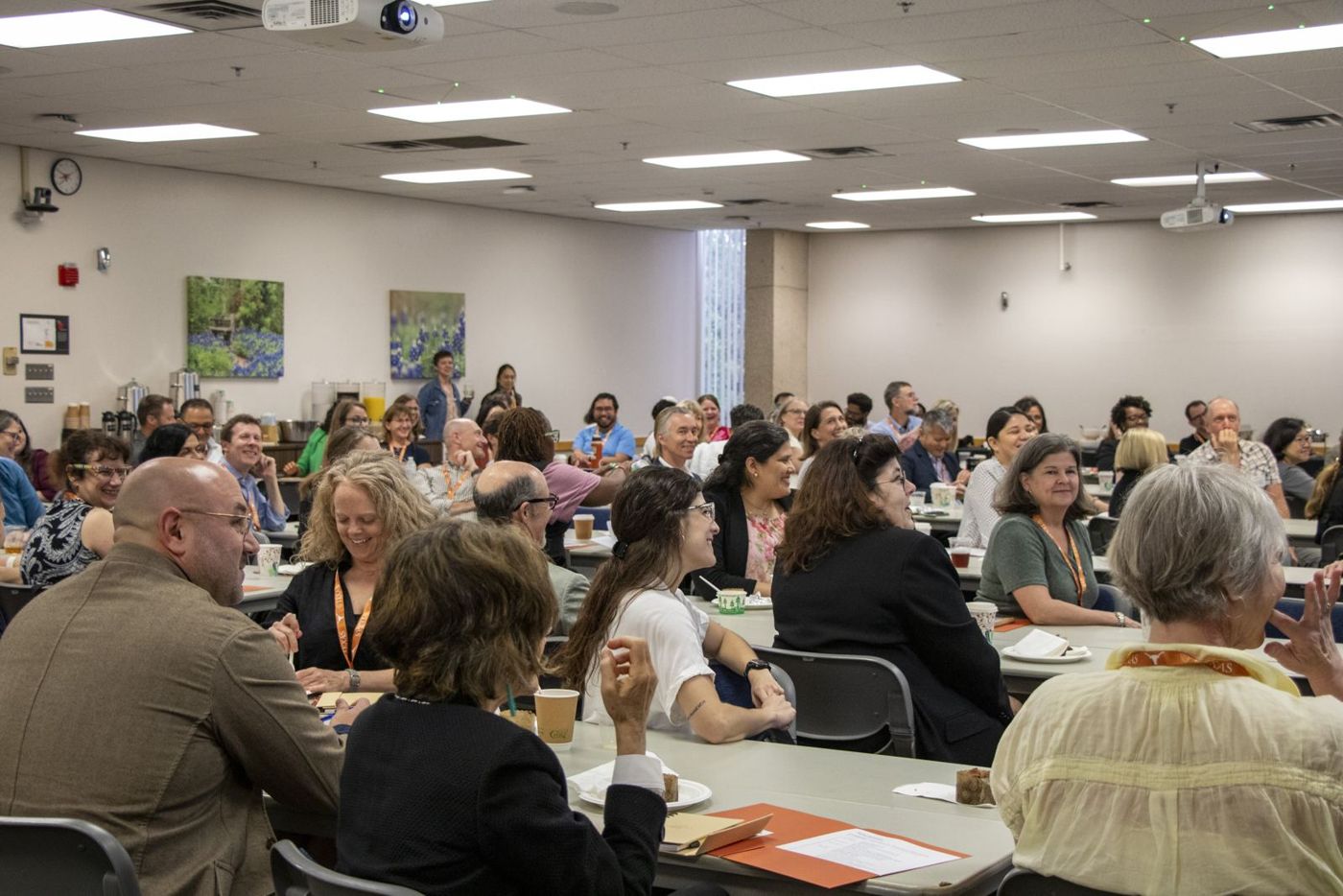 Faculty gathered in a conference room, smiling during a session
